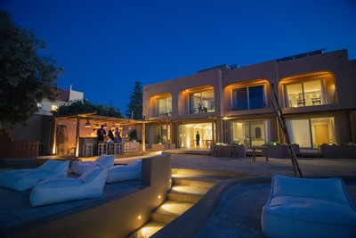 Evening view of The Theodore Boutique Hotel, elegantly lit with warm lights, featuring cozy outdoor seating and a serene ambiance. Evening view of The Theodore Boutique Hotel, elegantly lit with warm lights, featuring cozy outdoor seating and a serene ambiance.