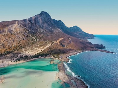 The image showcases the stunning Balos Lagoon in Crete, Greece, famous for its breathtaking turquoise waters, golden sands, and rugged mountainous backdrop. Located on the northwestern coast of Crete near Kissamos, Balos is one of the island's most iconic and picturesque beaches, accessible by boat or a scenic hike. The shallow, warm waters and unique blend of white and pinkish sand make it a must-visit destination for nature lovers and photographers alike. The image showcases the stunning Balos Lagoon in Crete, Greece, famous for its breathtaking turquoise waters, golden sands, and rugged mountainous backdrop. Located on the northwestern coast of Crete near Kissamos, Balos is one of the island's most iconic and picturesque beaches, accessible by boat or a scenic hike. The shallow, warm waters and unique blend of white and pinkish sand make it a must-visit destination for nature lovers and photographers alike.