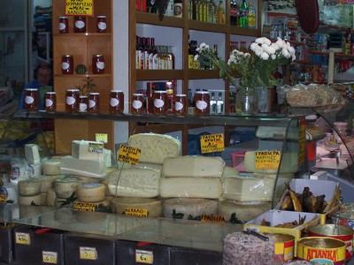 Selection of traditional Cretan cheeses on display at a stall in Chania Market, Crete, alongside jars of local preserves and olive oil. Selection of traditional Cretan cheeses on display at a stall in Chania Market, Crete, alongside jars of local preserves and olive oil.