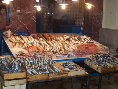 Fresh seafood display at a fish stall in Chania Market, Crete, featuring a variety of fish and shellfish arranged on ice under warm lighting. Fresh seafood display at a fish stall in Chania Market, Crete, featuring a variety of fish and shellfish arranged on ice under warm lighting.