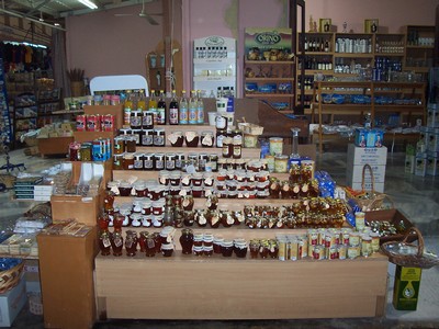 Display of honey jars, olive oil, and local Cretan products at a stall in Chania Market, Crete, showcasing a variety of traditional food items. Display of honey jars, olive oil, and local Cretan products at a stall in Chania Market, Crete, showcasing a variety of traditional food items.
