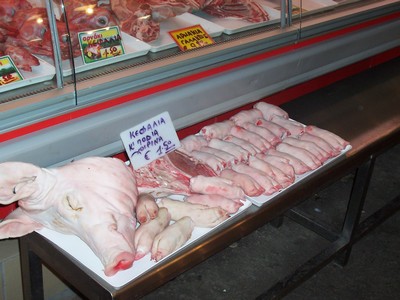 Fresh pork cuts, including a pig's head, displayed at a butcher stall in Chania Market, Crete, showcasing traditional meat selections. Fresh pork cuts, including a pig's head, displayed at a butcher stall in Chania Market, Crete, showcasing traditional meat selections.