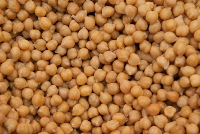A close-up of cooked chickpeas, showing their plump, round shape and golden hue. These protein-rich legumes are a staple in Mediterranean and Cretan cuisine, used in soups, salads, and traditional dishes like revithada (chickpea stew).