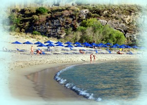 Crete nudist beach at plakias, Crete. Sandy beach with gentle waves, lined with blue umbrellas and sun loungers, set against a backdrop of lush greenery and rocky cliffs. Crete nudist beach at plakias, Crete. Sandy beach with gentle waves, lined with blue umbrellas and sun loungers, set against a backdrop of lush greenery and rocky cliffs.