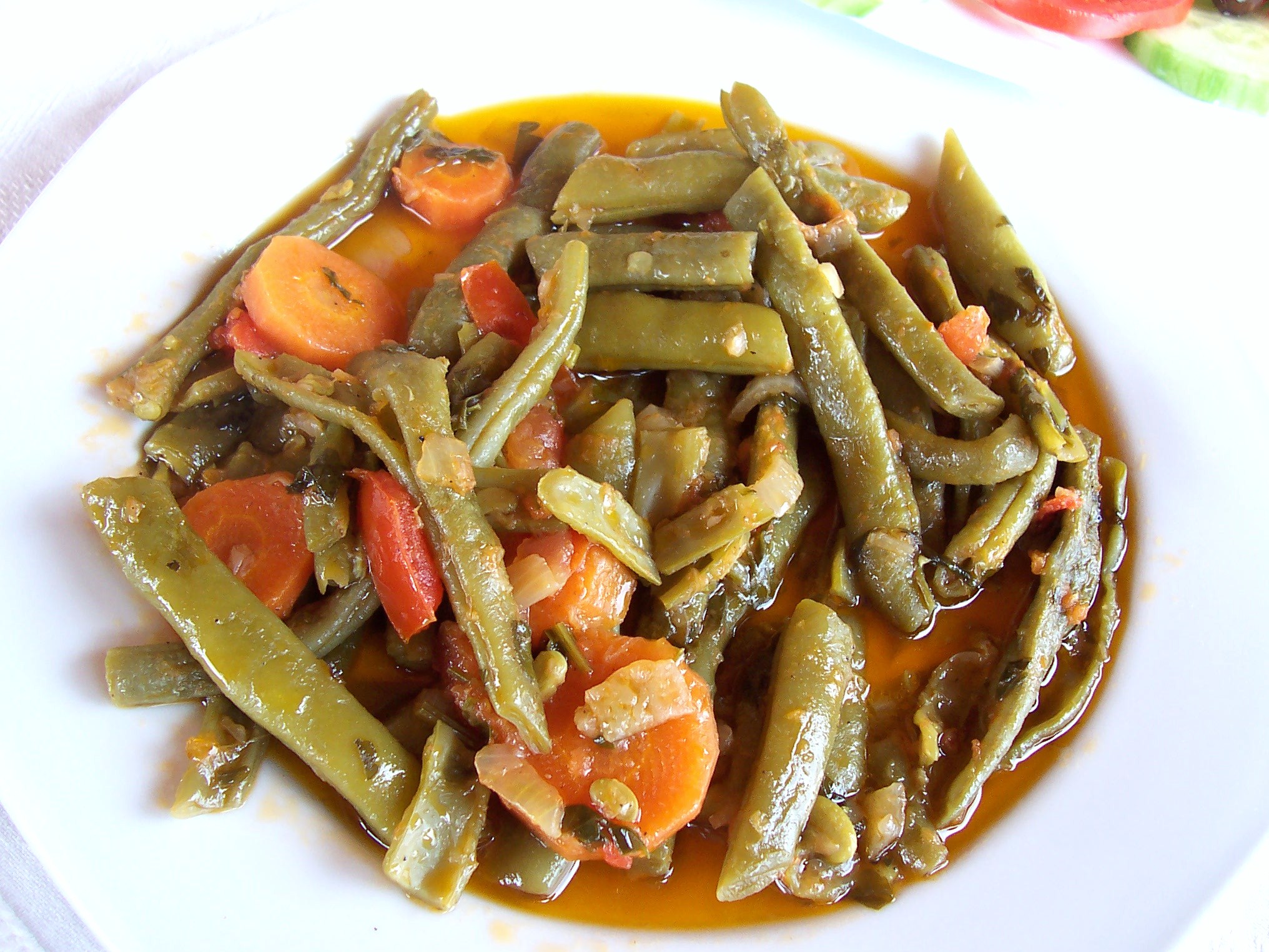 Plate of traditional Greek green beans (Fasolakia) cooked in olive oil with carrots, tomatoes, and onions, served in a rich, flavorful sauce. Plate of traditional Greek green beans (Fasolakia) cooked in olive oil with carrots, tomatoes, and onions, served in a rich, flavorful sauce.