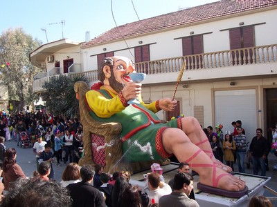 A vibrant scene from the Kalyves Carnival in Crete, featuring a giant, colourful float parading through the streets as crowds of festival-goers in costumes enjoy the lively celebration. A vibrant scene from the Kalyves Carnival in Crete, featuring a giant, colourful float parading through the streets as crowds of festival-goers in costumes enjoy the lively celebration.