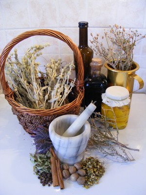 A beautiful assortment of Cretan culinary and medicinal treasures: a basket of dried herbs, a marble mortar and pestle, spices, and jars of olive oil and preserved herbs, evoking the essence of traditional Cretan living. A beautiful assortment of Cretan culinary and medicinal treasures: a basket of dried herbs, a marble mortar and pestle, spices, and jars of olive oil and preserved herbs, evoking the essence of traditional Cretan living.