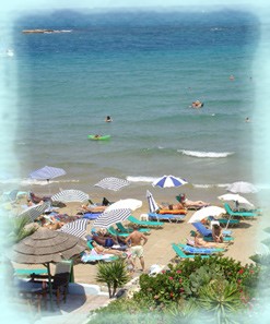 View of beach umbrellas and crystal blue waters at Stalis Beach.