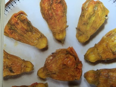 A plate of traditional Cretan stuffed courgette flowers, neatly arranged in a circular pattern, golden and lightly crisp, filled with a savory rice and herb mixture. A plate of traditional Cretan stuffed courgette flowers, neatly arranged in a circular pattern, golden and lightly crisp, filled with a savory rice and herb mixture.