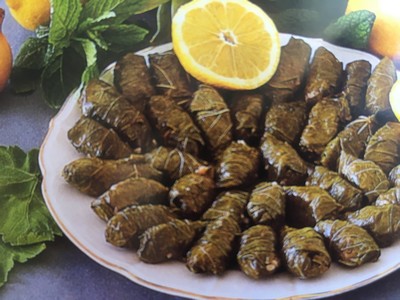 A plate of traditional Cretan stuffed vine leaves, neatly arranged in a circular pattern, garnished with fresh mint leaves and slices of lemon for a vibrant, fresh presentation. A plate of traditional Cretan stuffed vine leaves, neatly arranged in a circular pattern, garnished with fresh mint leaves and slices of lemon for a vibrant, fresh presentation.