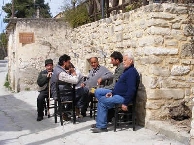 Cretan men chatting on chairs in the street