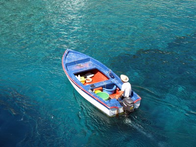 Blue fishing boat on the way out to sea